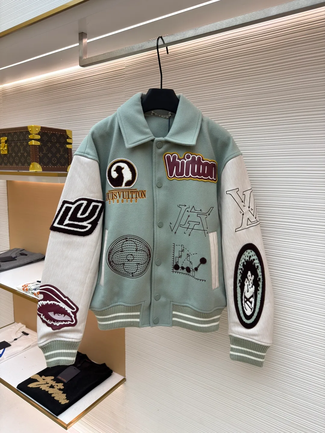 LOUIS VUITTON letter pattern patch printed color block baseball jersey ●Original version: 38999 purchase and development ●Item number: 1681672-D15 ●Fabric: sheep wool fabric ●Technology: printing production ●Color: green ●Version: fitted version ●Weight: about 1220 grams ●Size: 46-48-50-52 ●Description: This jacket is made of high-quality wool blended fabric, which is soft to the touch and has excellent warmth retention. The overall design adopts a lapel design, and the collar, cuffs and hem are all ribbed, with moderate elasticity, comfortable to wear and not easy to deform. The main part uses multi-color splicing technology. The gray and white splicing lines are smooth and natural, showing superb tailoring technology. The patterns on the chest and sleeves are embroidered and appliquéd, with distinct layers and a strong three-dimensional effect. Multi-colored silk threads are interwoven during the embroidery process to ensure that the pattern is clear and durable. The buttons of the jacket are made of metal, with a smooth surface and not easy to fade. The splicing of the shoulders and sleeves adopts seamless technology, with smooth and natural lines without excess threads. The overall workmanship is fine, and every stitch is even and neat, reflecting the high-quality production process. The overall wiring is straight and delicate, the fabric is comfortable and soft, and the color is consistent without color difference. It can be matched with the same style to create a fashionable look and control various occasions. Customized accessories, complete with three standards, same style for men and women!